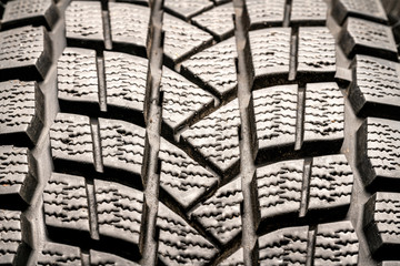 Protector close-up of old used winter tires. on black background.