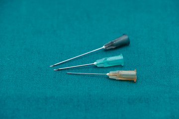 Three color of injection needle isolated on surgical green drape