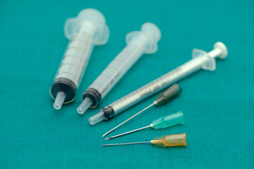 Three color of injection needle with blank syringe isolated on surgical green drape