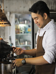 Happy Asian barista man working in cafe, lifestyle concept.