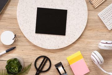 blank blackboard mock up on office desk table top view with stationery,notebook,plant on wooden table background.smart phone screen for display of design.business object flat lay