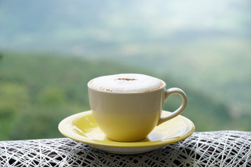 Hot coffee in green nature background.