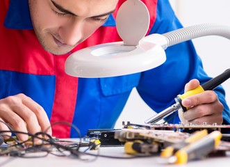 Professional repairman repairing computer in workshop