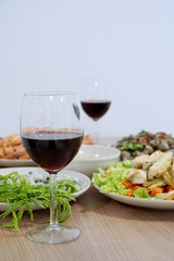 Selective focus, Glass of wine red on blurred food on the table as a background, set of dinner, Vertical