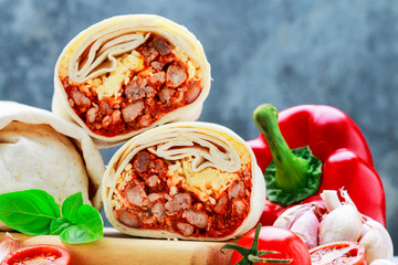 A burrito - mexican dish that consists of a flour tortilla with various ingredients.