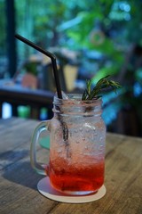 Selective focus of strawberry italian soda in glass on table in café ready to drink or serve, on dark background, Vertical