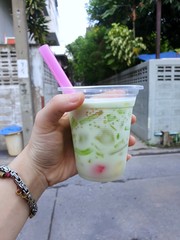 Selective focus of hand holding Chendol dessert in coconut milk at street food in Thailand, Lod Chong is thai traditional (Cendol, Dawet), Vertical, Ready to eat