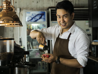 Happy Asian barista man working in cafe, lifestyle concept.