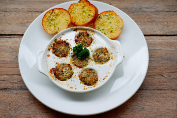 Baby Clam Escargot Style on wood table