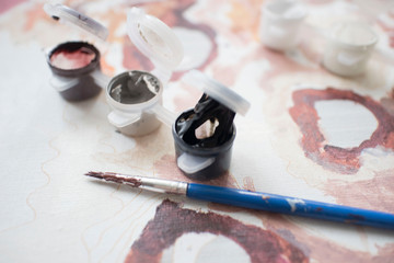 colored paint with a brush of the artist on the background of the painting