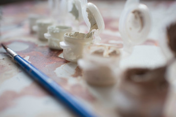 colored paint with a brush of the artist on the background of the painting