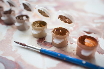 colored paint with a brush of the artist on the background of the painting