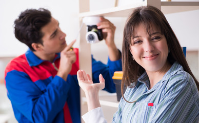 Client getting securty camera installed at home by contractor