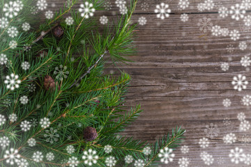Winter holidays concept,frame of snowflakes and fir branches on wooden background with copy space