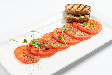 tomato carpaccio with toasts on white plate