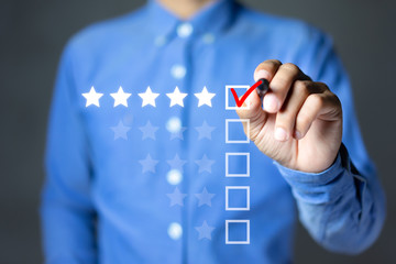 Businessman putting check mark a checkbox on five star rating. Increase rating company or ranking,...