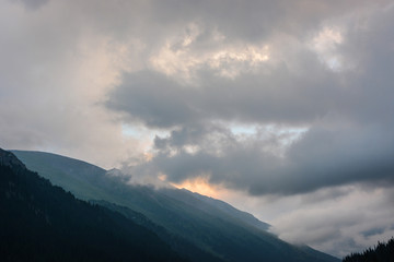 Beautiful landscape mountains with clouds and grey sky in evening. Peaceful outdoor scene.