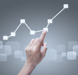 Hand touching graphs of financial indicator