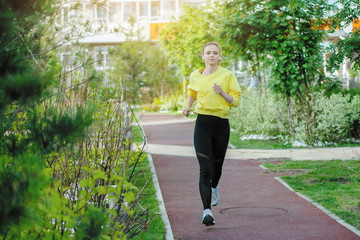 Sport woman in yellow is training in an urban environment.