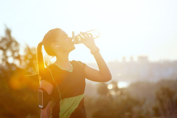 Woman resting after warm-up run with glass in hand