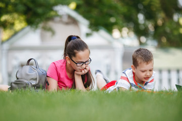 Fototapeta premium Four children sitting on the green grass.
