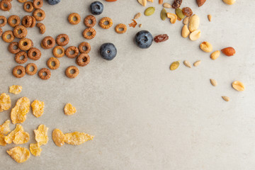 muesli and cereals are scattered with jars of blueberries and sweet cookies on a light background, breakfast background.flat lay? top view