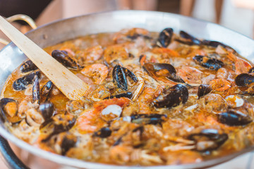 Authentic image of Beautiful Spanish paella with seafood while cooking