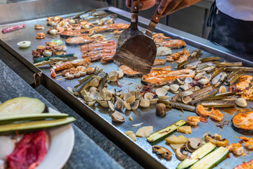 Assortment of seafood was cooking on grilling table at restaurant