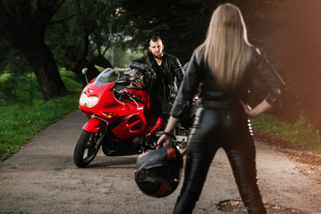 Obraz na płótnie Canvas man and woman in leather with sports motor bike