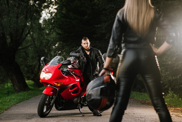 Fototapeta na wymiar man and woman in leather with sports motor bike