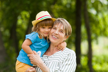 Happy grandmother with her grandchild  spend time together in the summer outdoors.