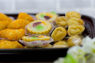 variety of traditional indonesian cake's inside plastic packaging on wood and white brick background