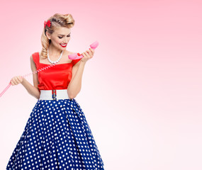 smiling woman with phone, dressed in pin-up style dress
