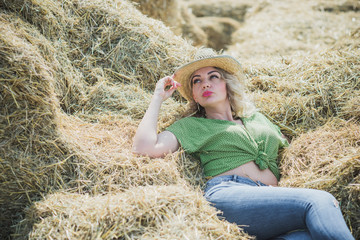 Naklejka na ściany i meble A woman of plus size, American country style, enjoying life, lady with excess weight, stylishly dressed in straw hat denim pants and polka dot shirt. Natural beauty