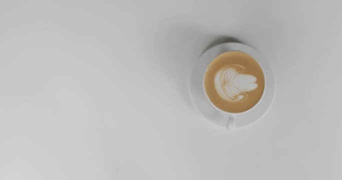 Top view of faceless waiter serving cappuccino to woman inside cafe natural light. Male hands putting white cup with coffee on table and girl taking it slow motion. Restaurant  street food lifestyle