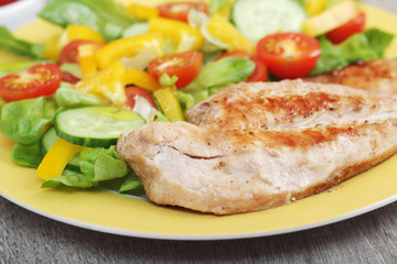 Grilled chicken breast with raw vegetables salad