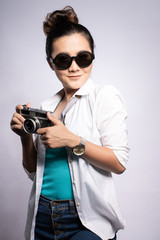 Obraz premium Happy woman holding camera over background and looking at camera