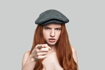I know everything about you. Portrait of young rude redhead woman in headgear looking at camera and...