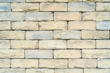 Texture of yellow brick made of sandstone and limestone. The wall of the house.