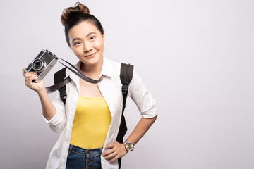 Happy woman holding camera over background and looking at camera