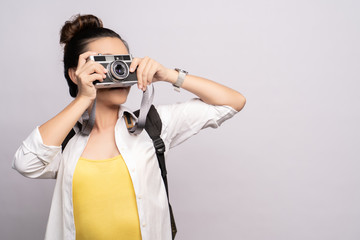 Happy woman take a photo by camera isolated over background