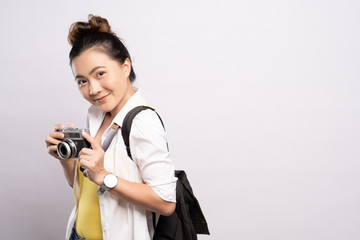 Happy woman holding camera over background and looking at camera