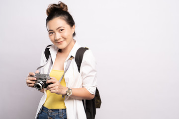 Happy woman holding camera over background and looking at camera