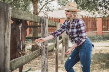 Pretty girl at countryside with horse. A beautiful rider and horse. Artistic Photography at horse farm. Attractive girl riding on horse rural location 