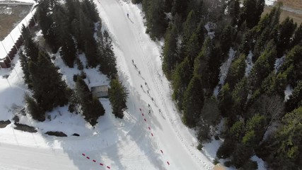 Aerial view Biathlon. Athletes students participating in local competitions. Passage of distance group of athletes in the mountains.