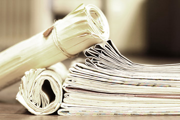 Newspapers Folded and Rolled. Stack of Magazines and Journals on the Table. Close up View of Business Papers with News, Pages with Headlines and Articles 
