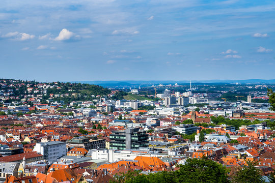 Germany, Wide view aerial above the red roofs of stuttgart city and feuersee church in basin surrounded by hills in summer