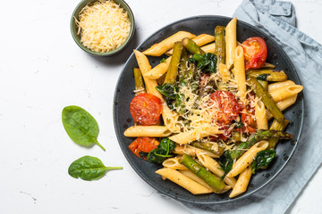 Vegan pasta penne with spinach, asparagus and tomato.