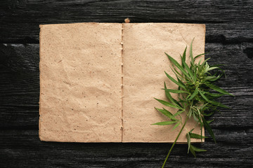 Cannabis cbd oil recipe blank book with a copy space on a black wooden table background.
