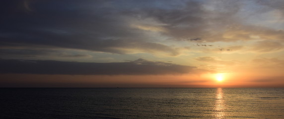 Obraz premium Sonnenaufgang nach einer Regennacht am Meer - Wolkenstimmung am frühen Morgen